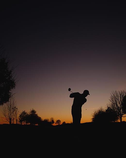Golfer im Sonnenuntergang auf der Anlage